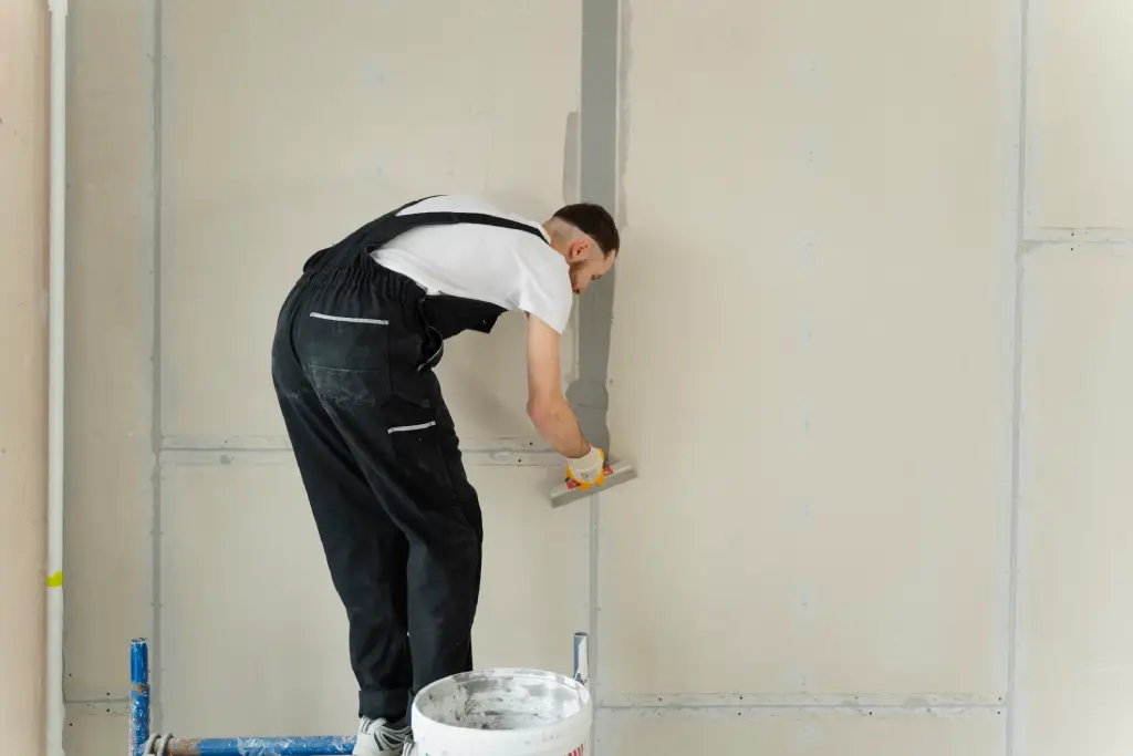 full-shot-construction-worker-using-plastering-trowel